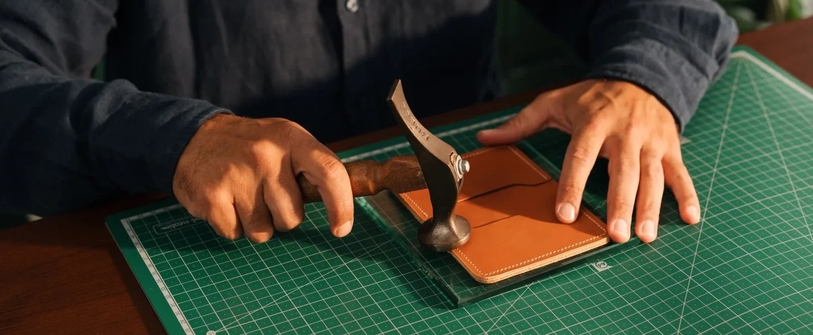 Artisan travaillant une piece de cuir a la main en atelier