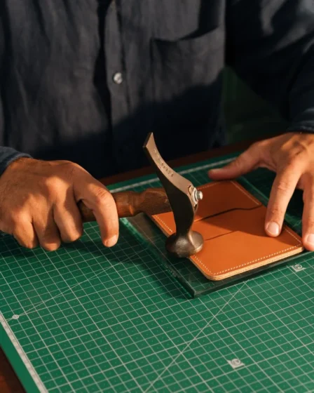 Artisan travaillant une piece de cuir a la main en atelier
