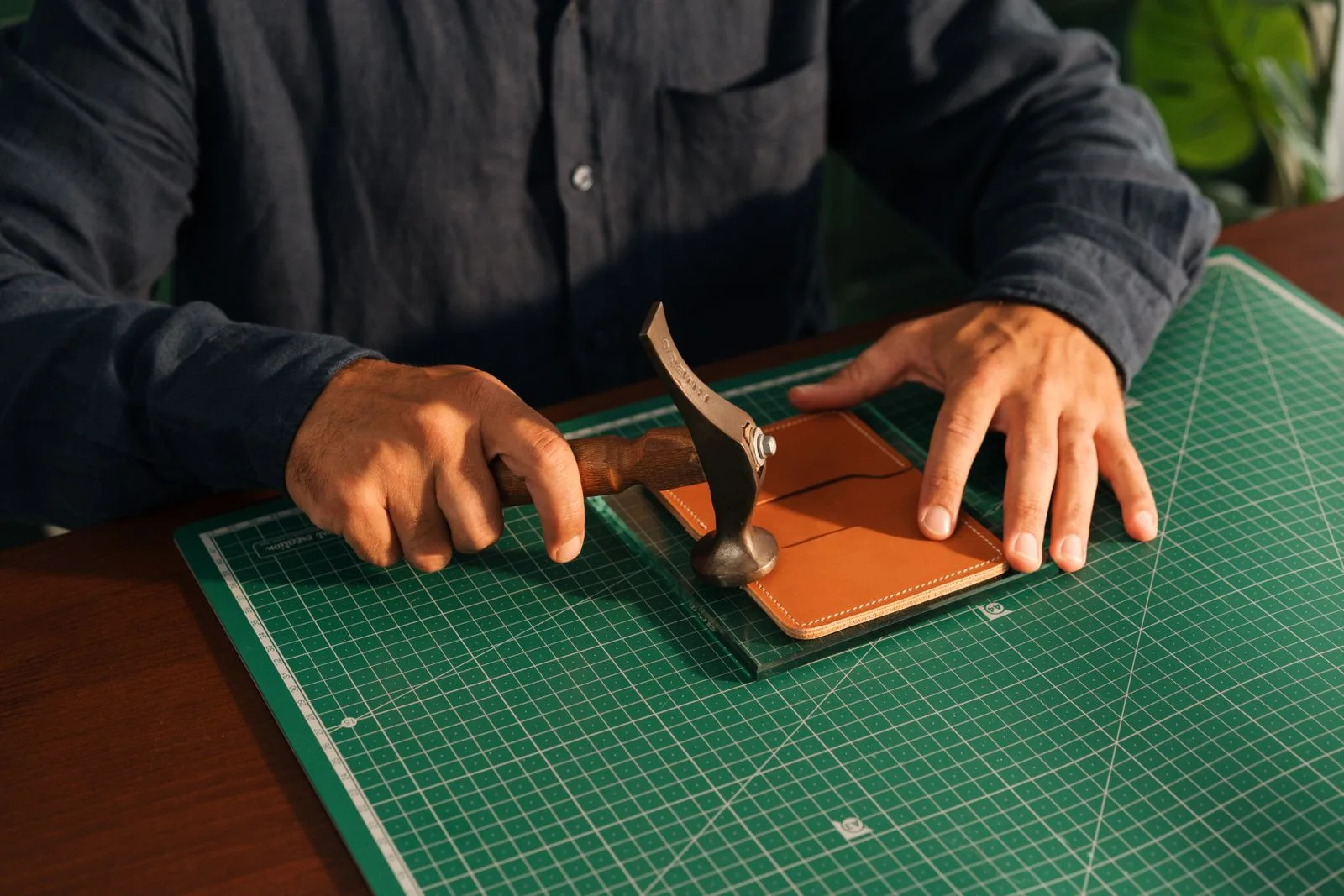 Artisan travaillant une piece de cuir a la main en atelier