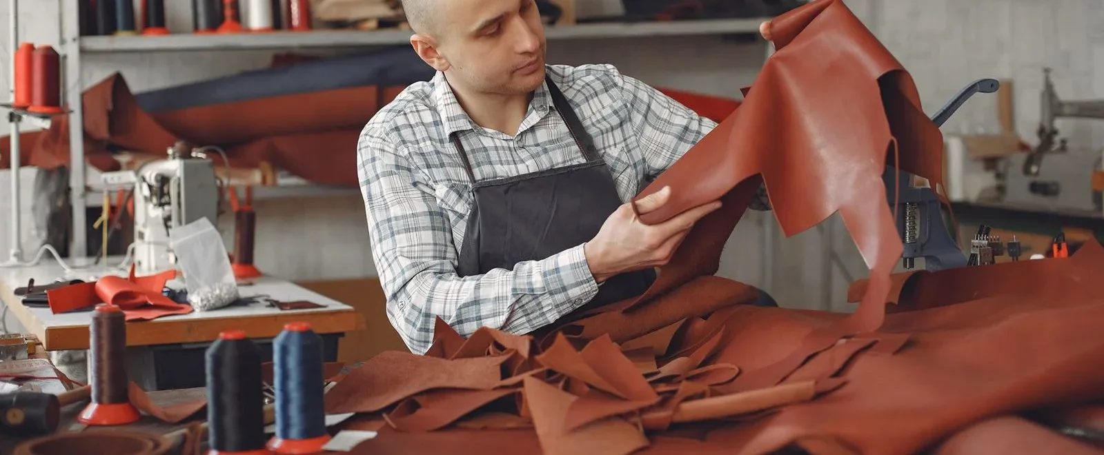 Artisan examinant une peau de cuir dans son atelier
