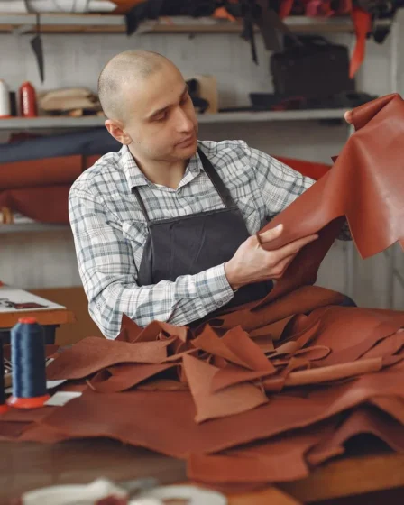 Artisan examinant une peau de cuir dans son atelier