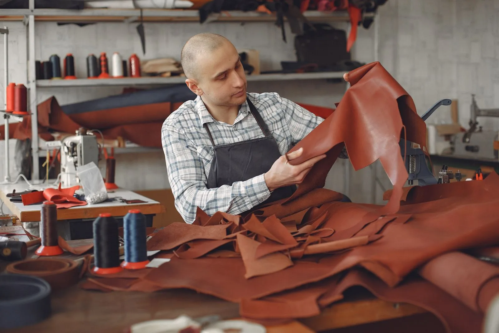 Artisan examinant une peau de cuir dans son atelier