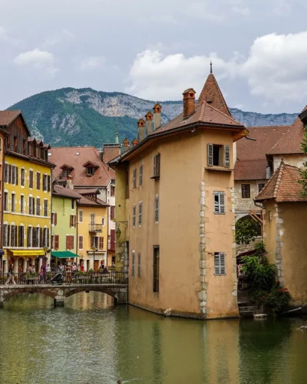 Canal du Thiou et façades colorées de la vieille ville d'Annecy, avec les montagnes en arrière-plan