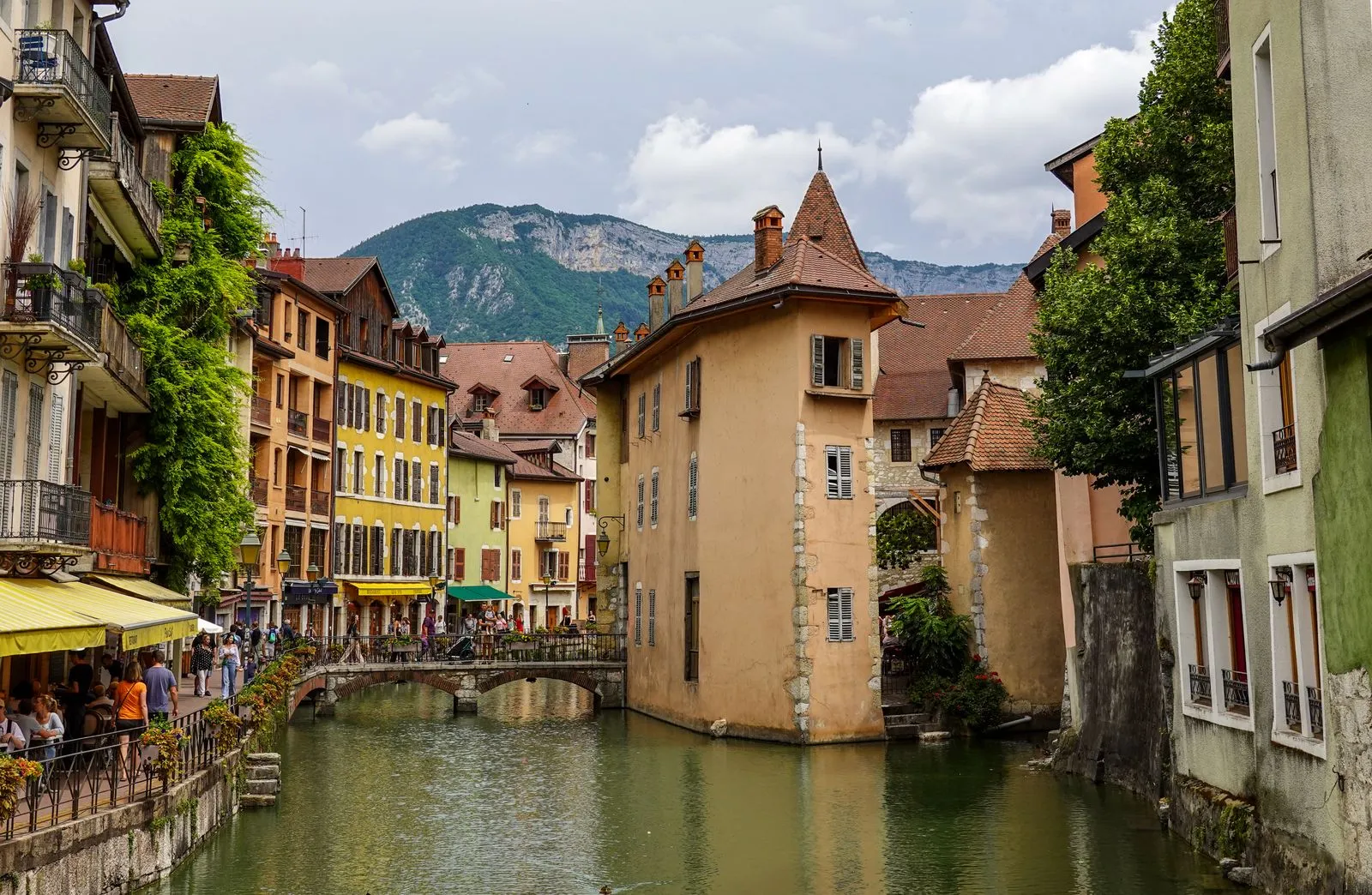 Canal du Thiou et façades colorées de la vieille ville d'Annecy, avec les montagnes en arrière-plan