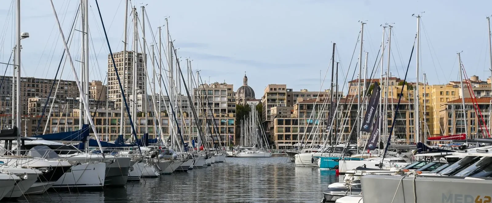 Voiliers amarrés au Vieux-Port de Marseille, immeubles du quai et dôme de la cathédrale de la Major en fond