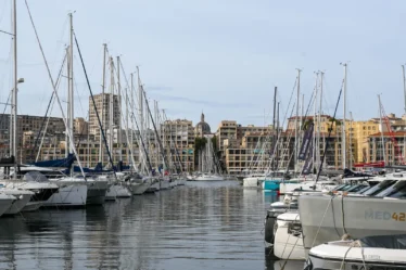 Voiliers amarrés au Vieux-Port de Marseille, immeubles du quai et dôme de la cathédrale de la Major en fond